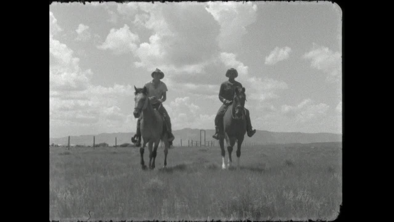 两个牛仔在怀俄明州的平原上骑马;1962视频素材