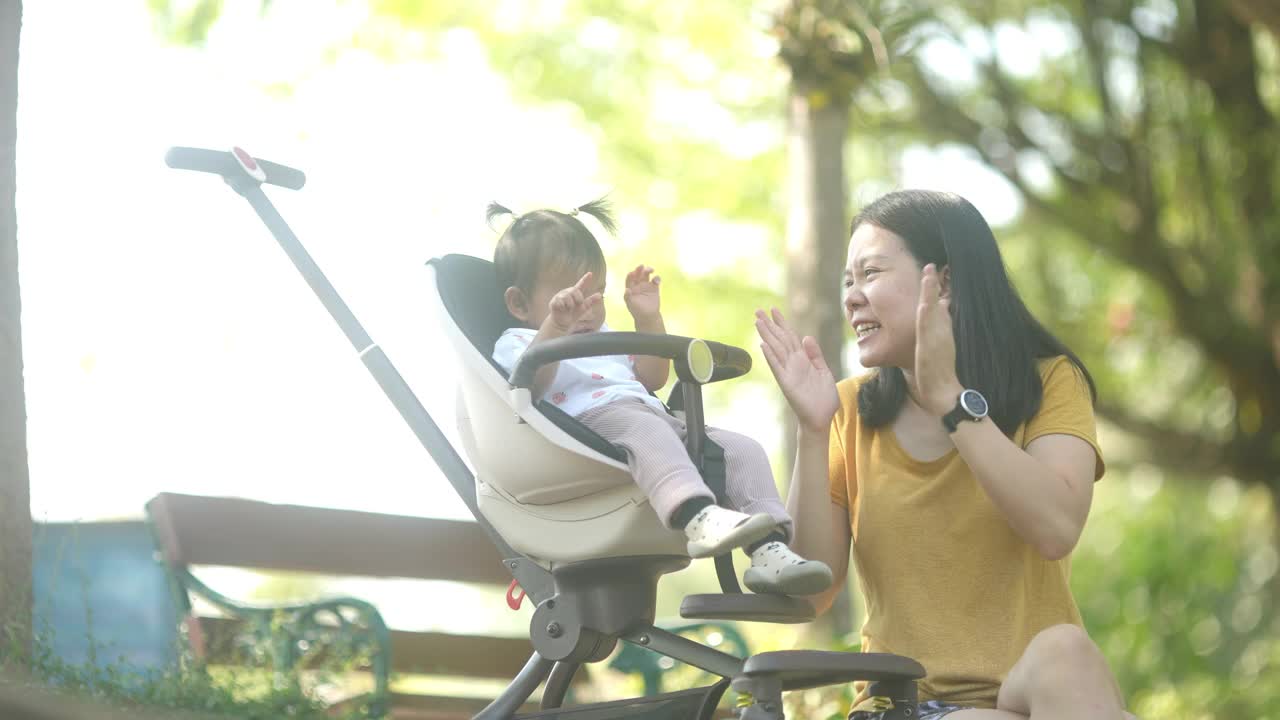 4k幸福时刻，亚洲母亲和女儿在公园慢跑结束后坐着放松视频下载