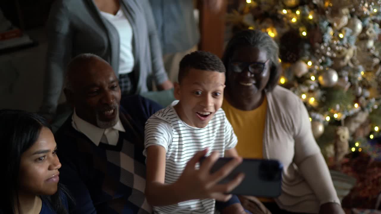 圣诞节期间，一家人在家里用智能手机视频通话视频素材
