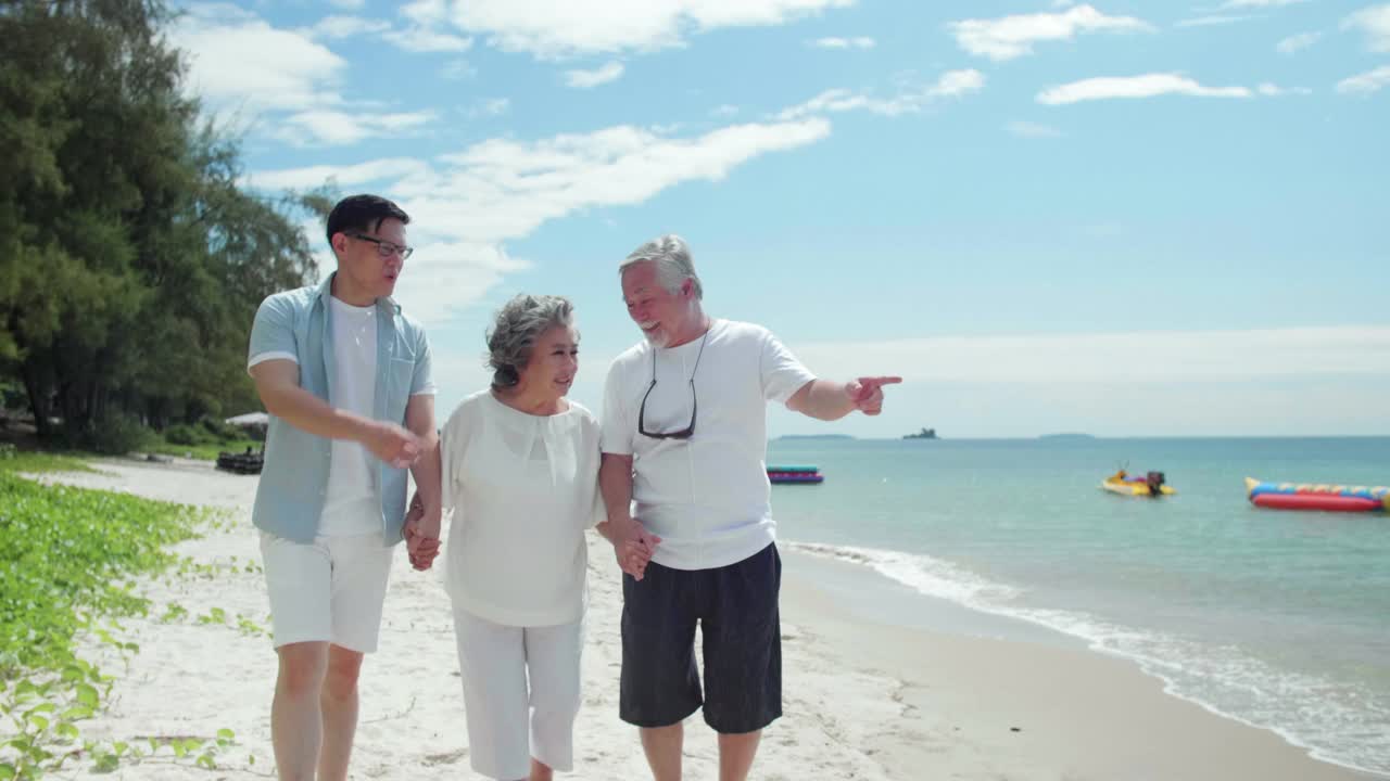 亚洲家庭的儿子和他的年长的父母一起走在海滩上视频下载