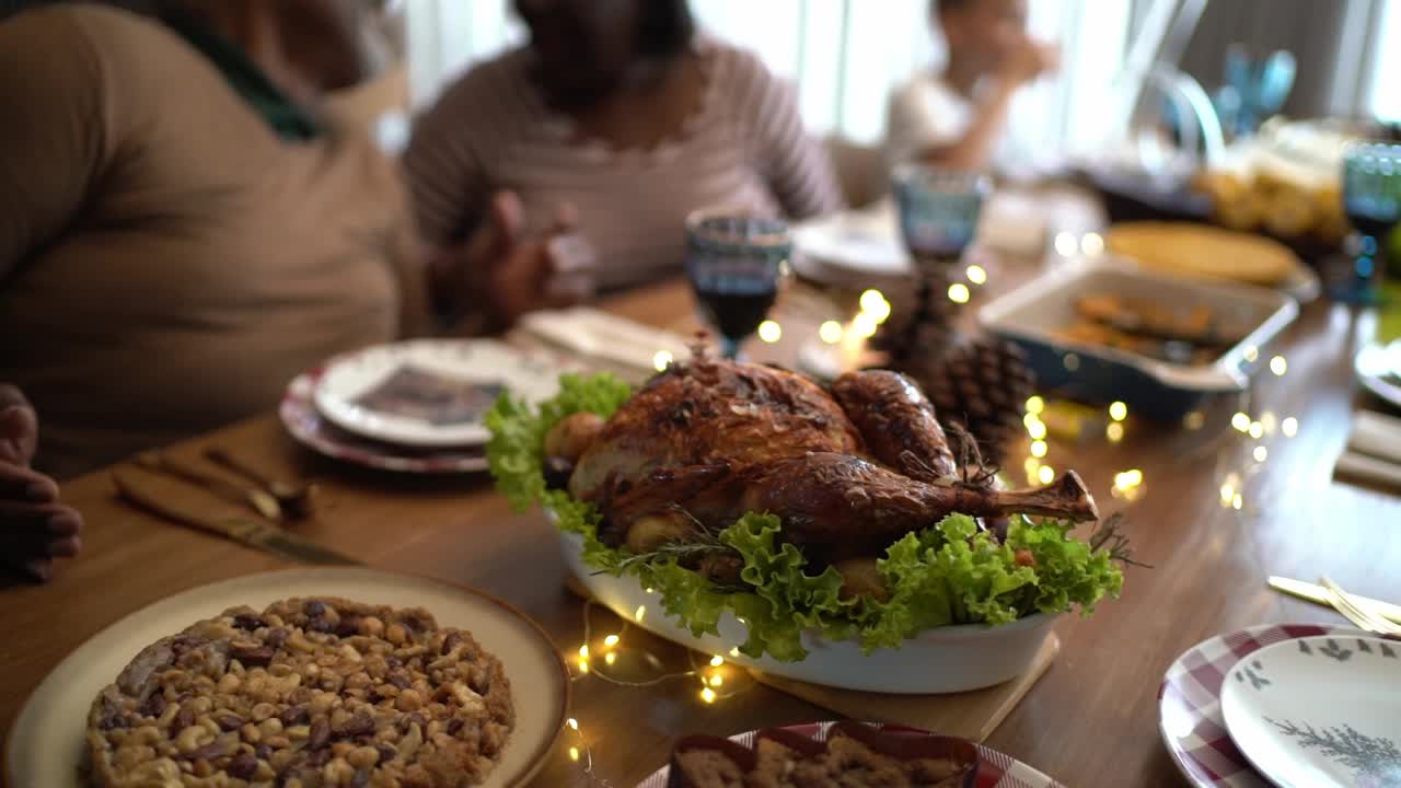 在圣诞节的餐桌上烤火鸡和家人在家里谈论背景视频素材
