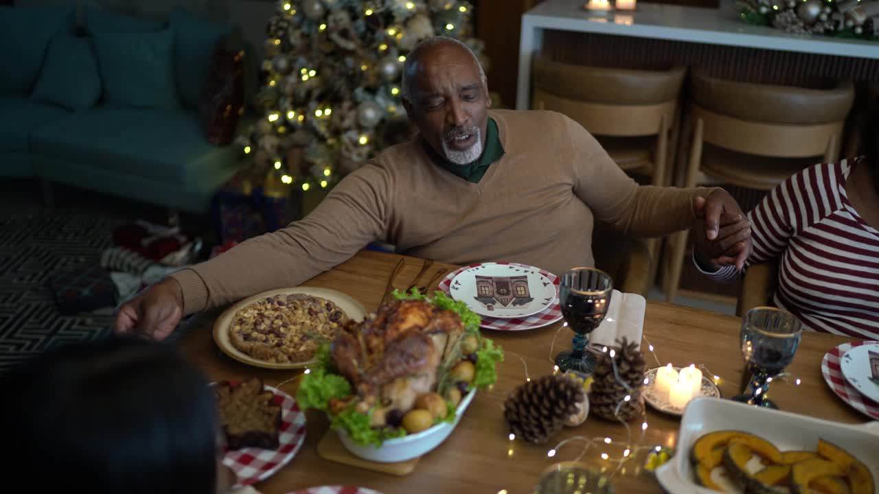 老夫妇与家人一起祈祷，在家里吃圣诞午餐或晚餐视频素材