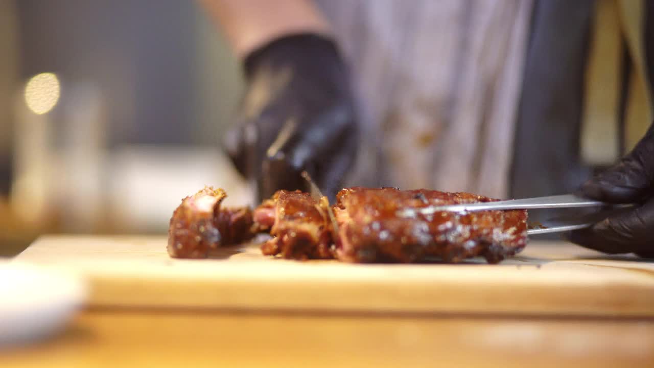 厨师切片多汁的猪腰排骨，在木制砧板上视频下载