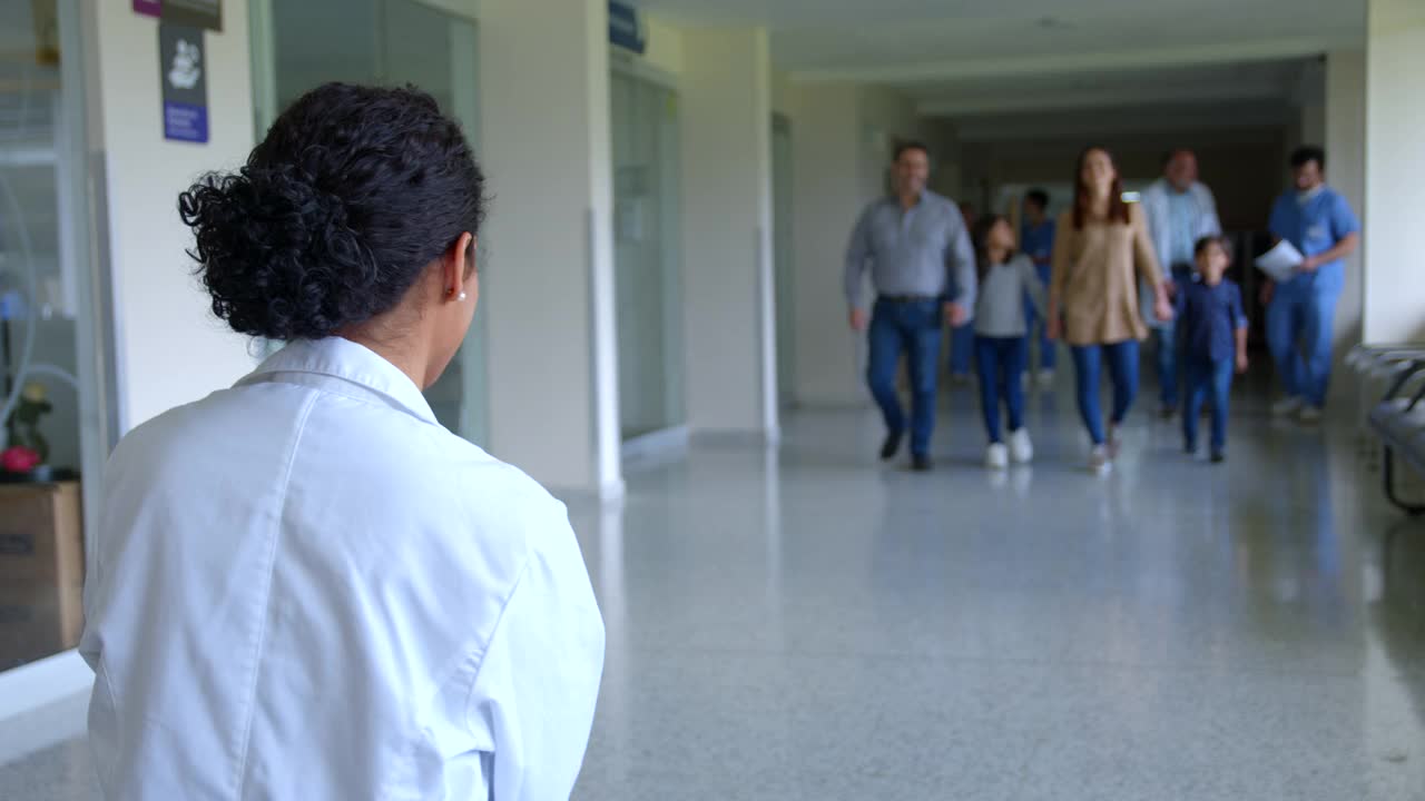 在医院的走廊里，可爱的小男孩跑过来和他的儿科医生非常亲热地拥抱视频素材