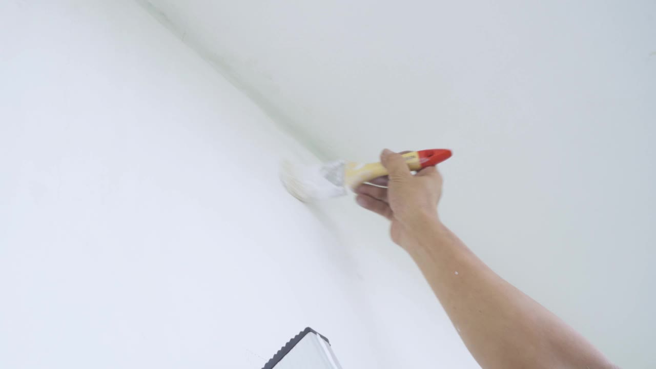 修理工用油漆刷手工粉刷墙壁视频素材