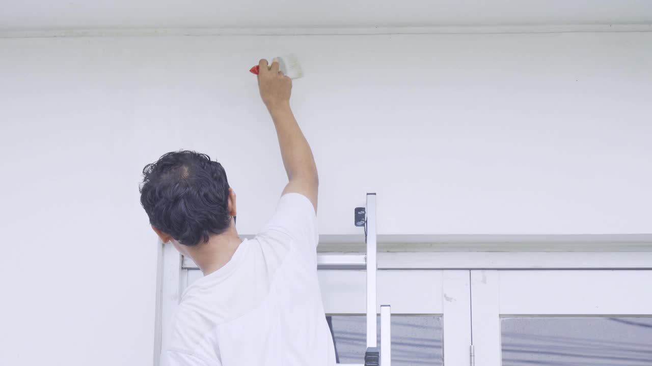 男工人粉刷墙壁的后视图视频素材