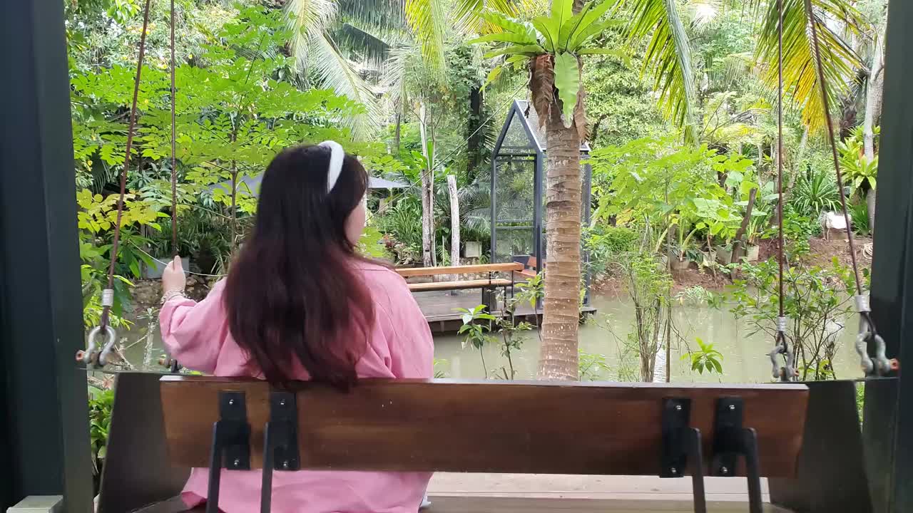 亚洲妇女在后院秋千视频素材