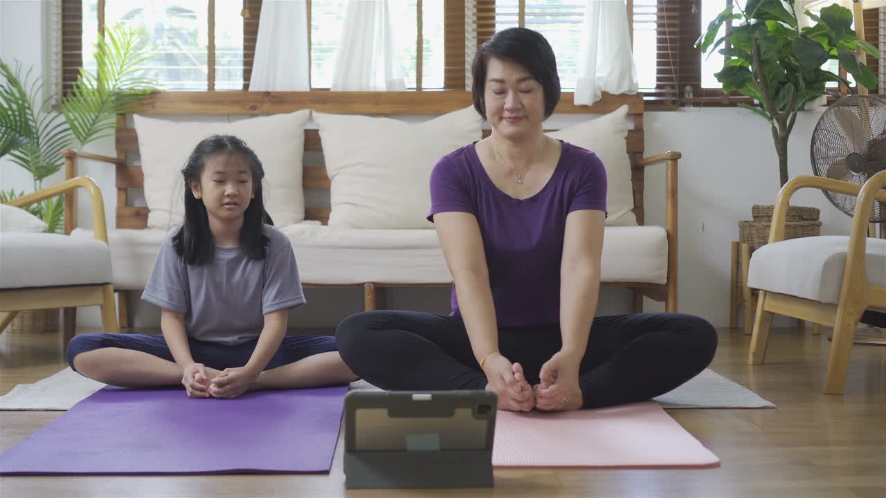 母亲和女儿在家锻炼。幸福的家庭的概念视频素材