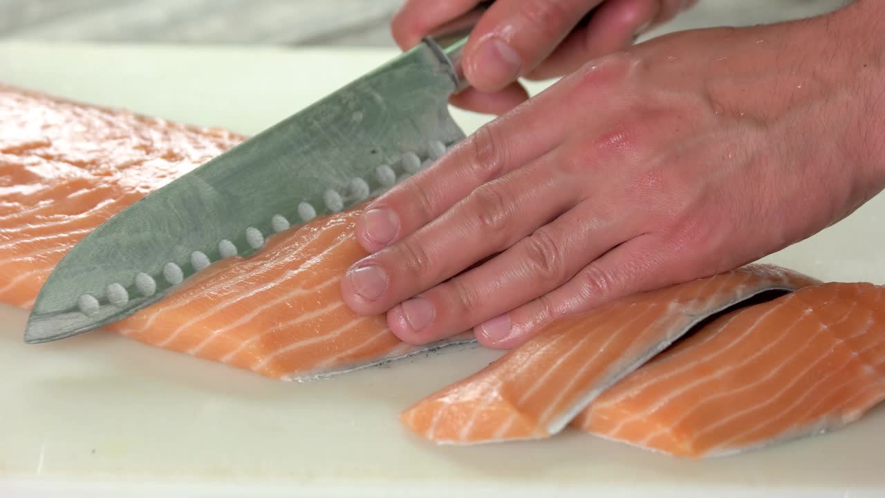 手切新鲜的鲑鱼。视频素材