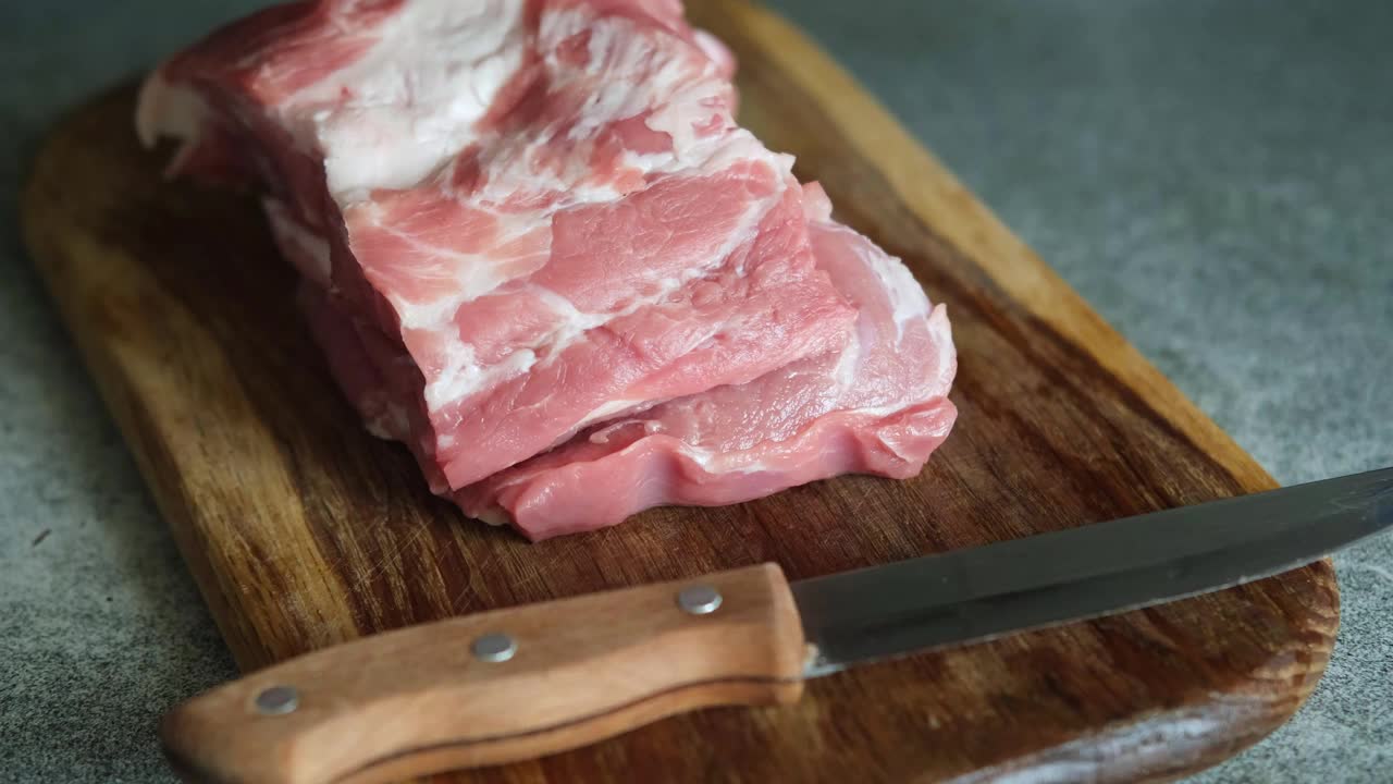 在木板上切一块生肉。视频下载