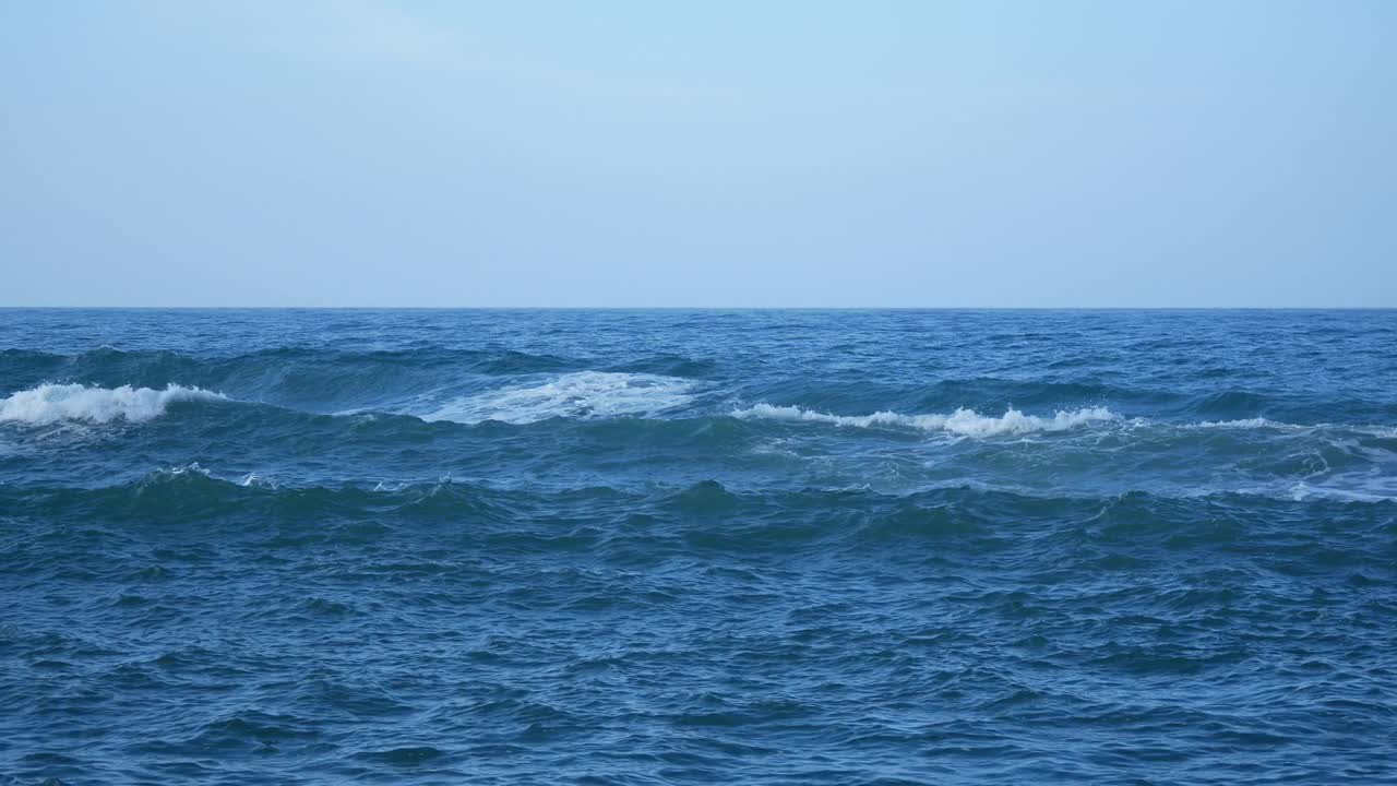 在阴冷的天空中，海浪带着大量的泡沫到达海岸视频素材