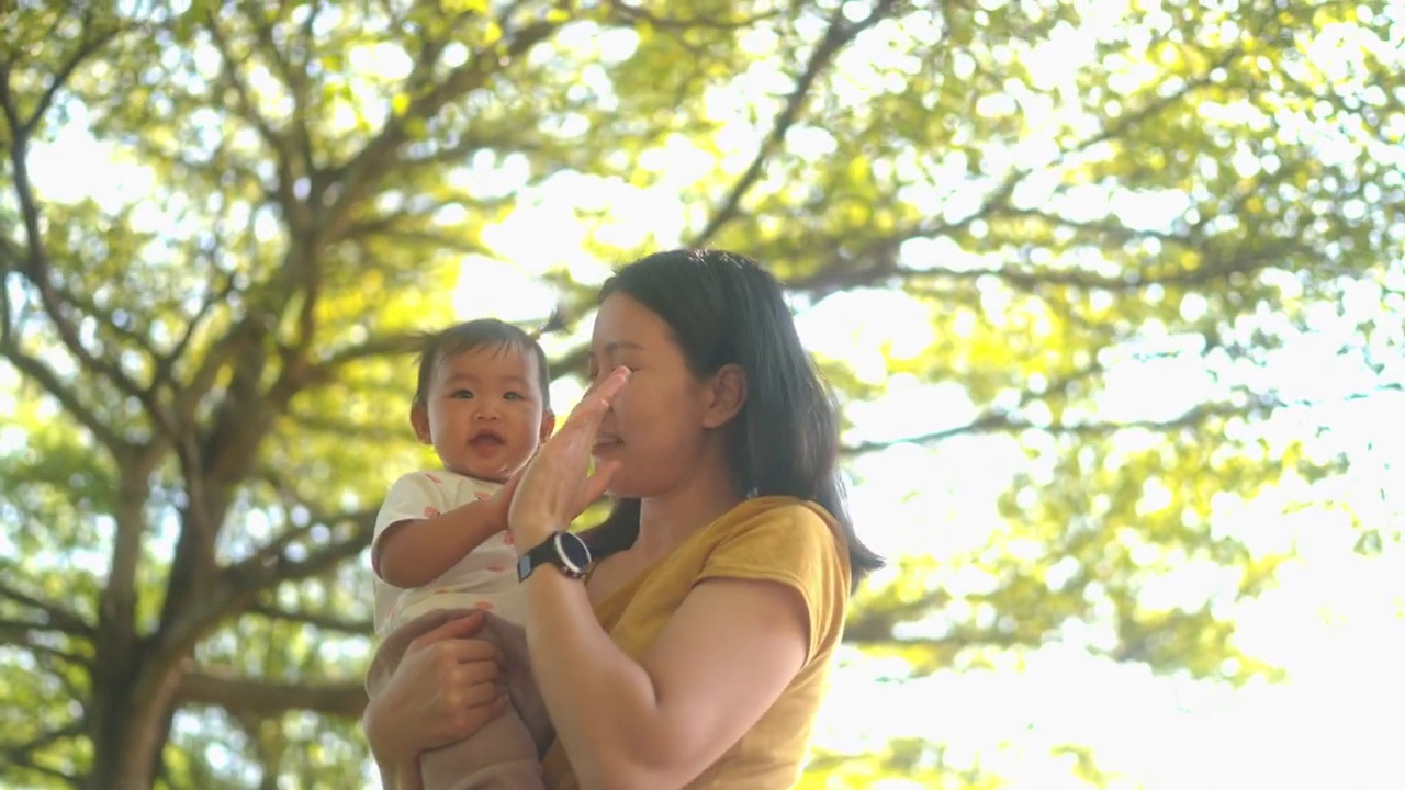 4k幸福时刻亚洲母亲在公园慢跑结束后，拥抱并亲吻女儿视频下载