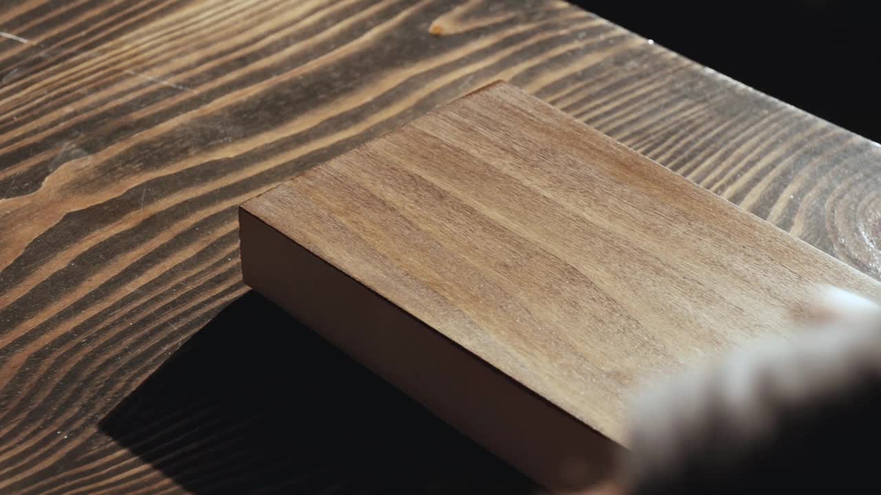 木匠涂木材染色。在木板上涂油木材浸渍的应用。木质表面的保护视频下载