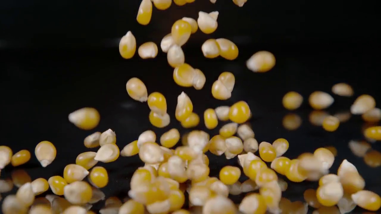 微黄的爆米花粒落在闪亮的厨房操作台面上。视频下载