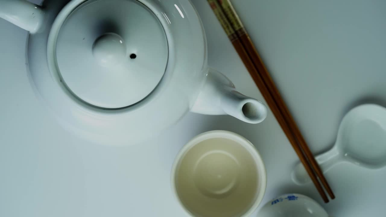 高角度的茶壶与茶杯和筷子视频下载