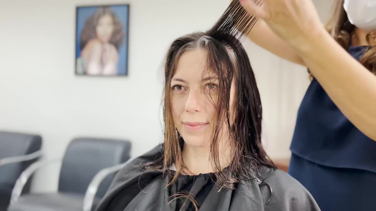 美发师在美容院为美丽的千禧少女理发视频下载
