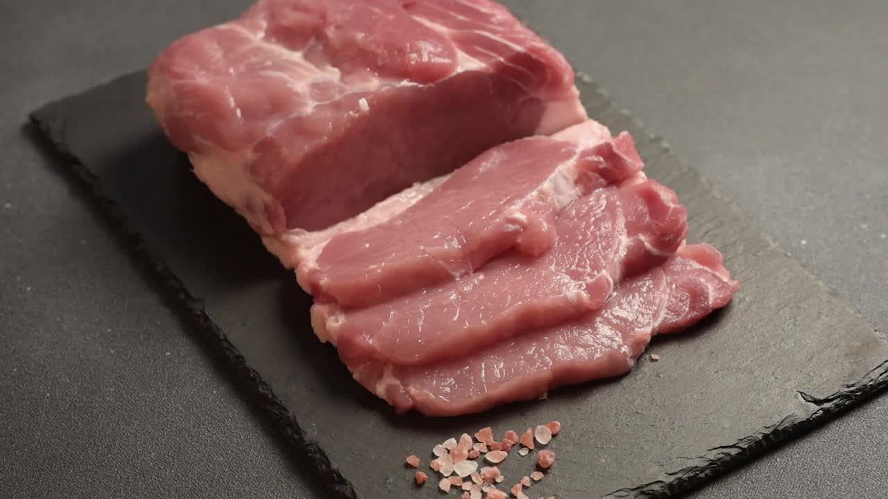 生猪肉排放在砧板上，配上香草和香料视频素材