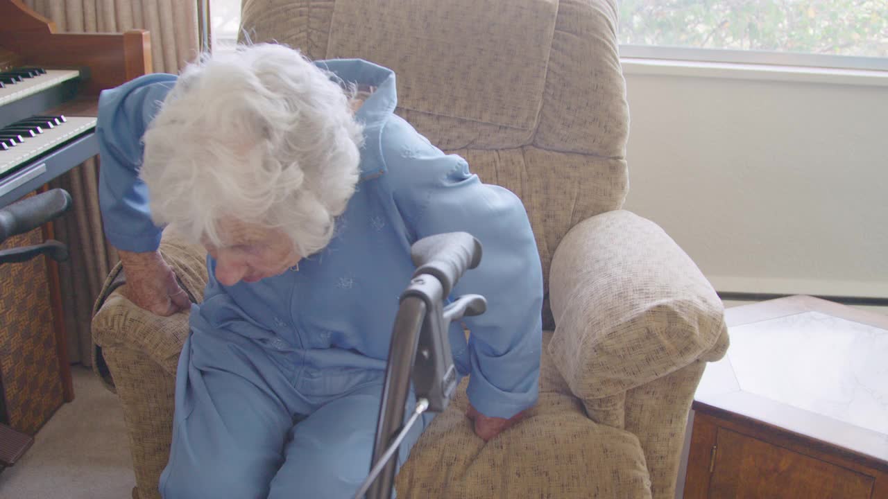 一位100岁的老妇人从躺椅上用助行器慢慢站起来视频下载