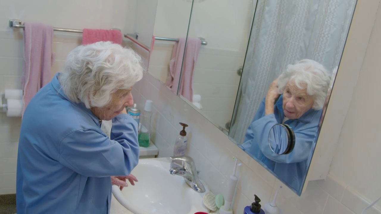 一位百岁老妇在照镜子，梳着头发视频下载