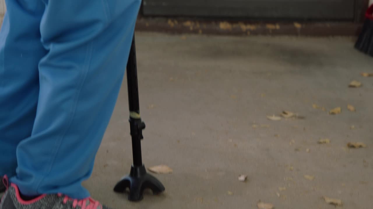 一位100岁的老妇人拄着拐杖站在一户人家的前门上，看着一张驱逐通知视频下载