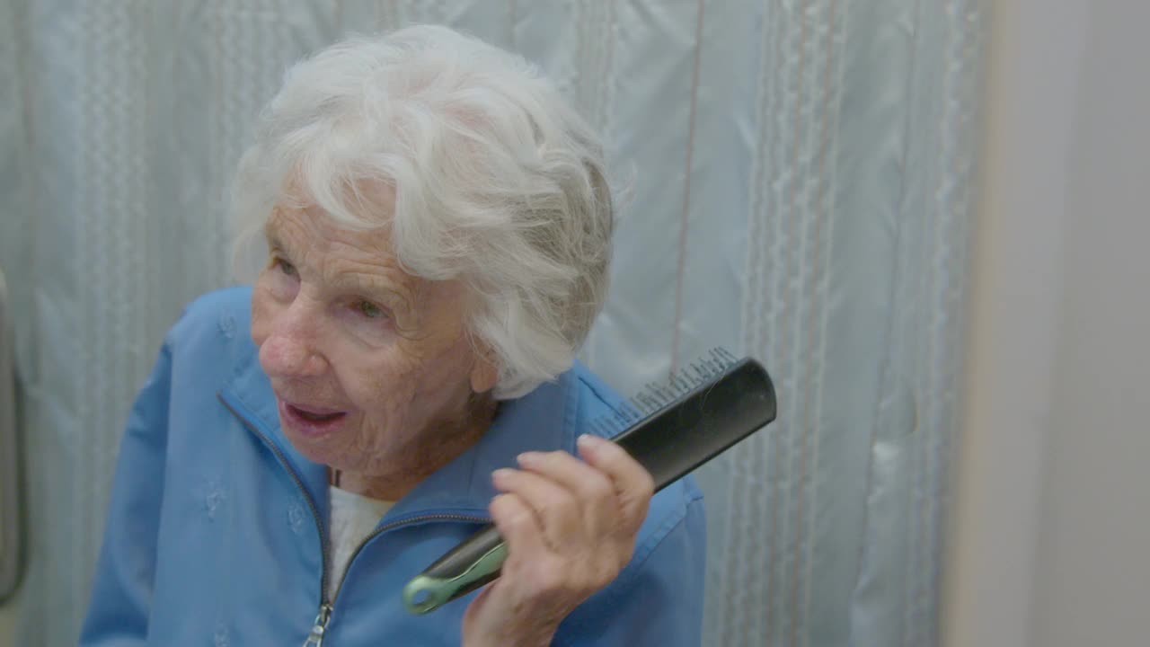 一位百岁老妇在照镜子，梳着头发视频下载