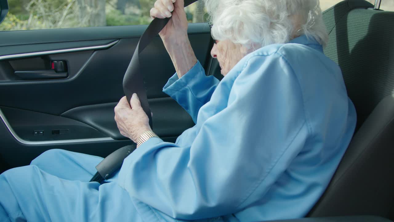老年白人妇女在车上伸手握住安全带扣视频下载