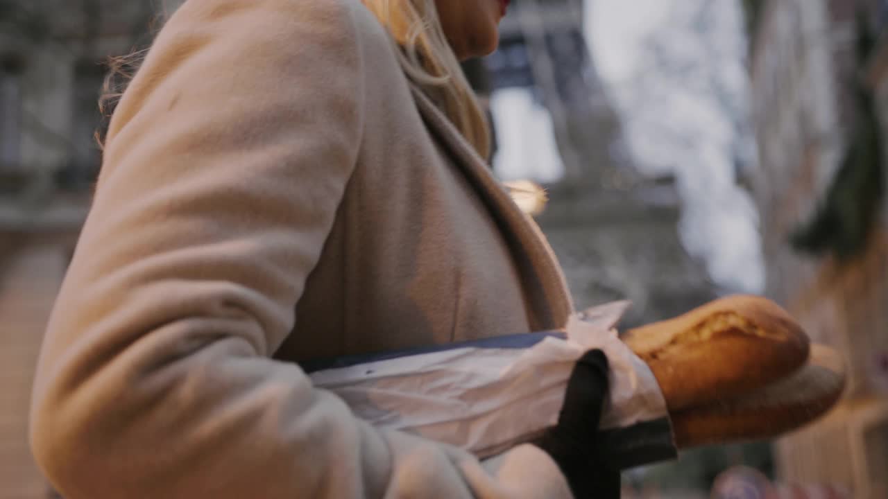 一个法国女人沿着艾菲尔铁塔走在街上，手里拿着长棍面包视频下载