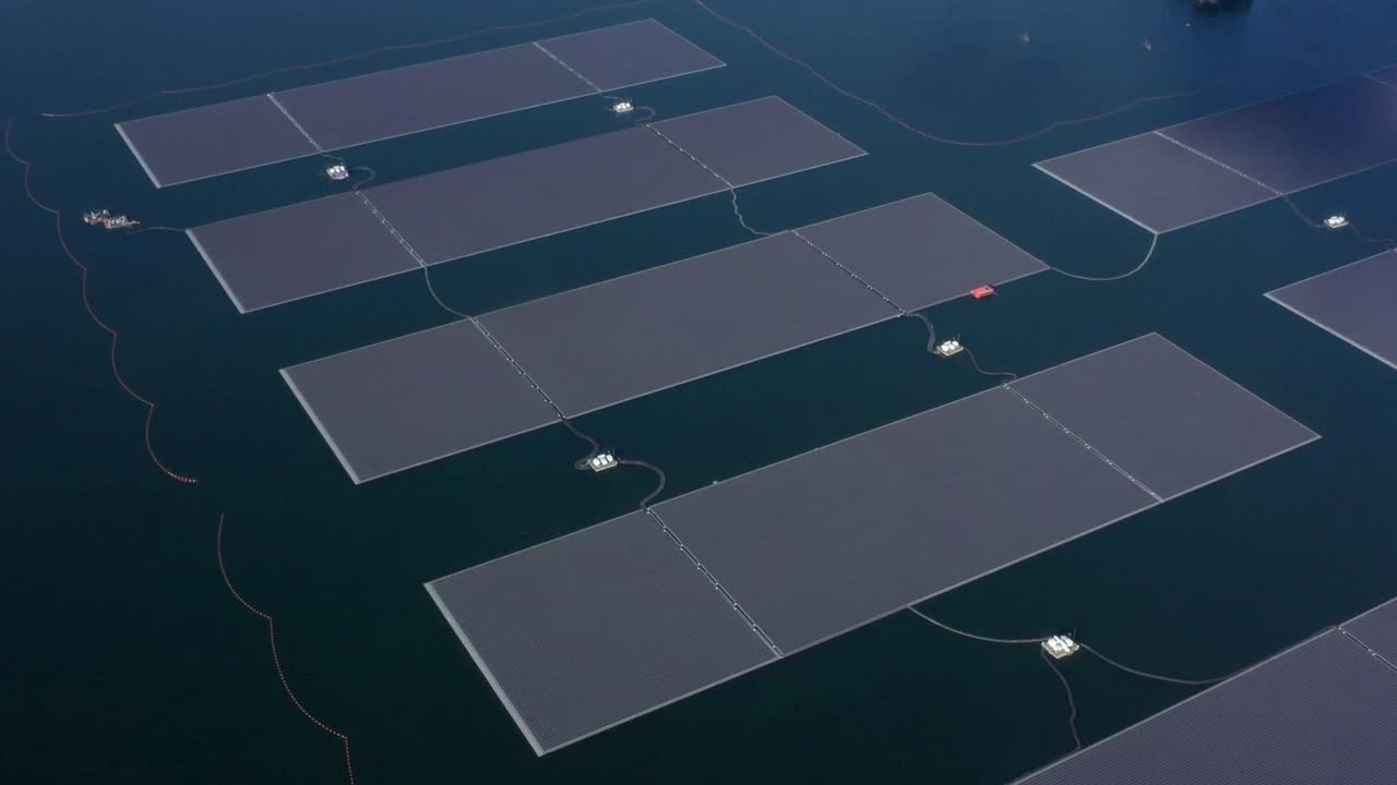 鸟瞰图浮动太阳能电池电站利用太阳能电池在湖中发电，浮动太阳能电池板和电池平台在水上生态能源，可替代可再生能源。视频素材