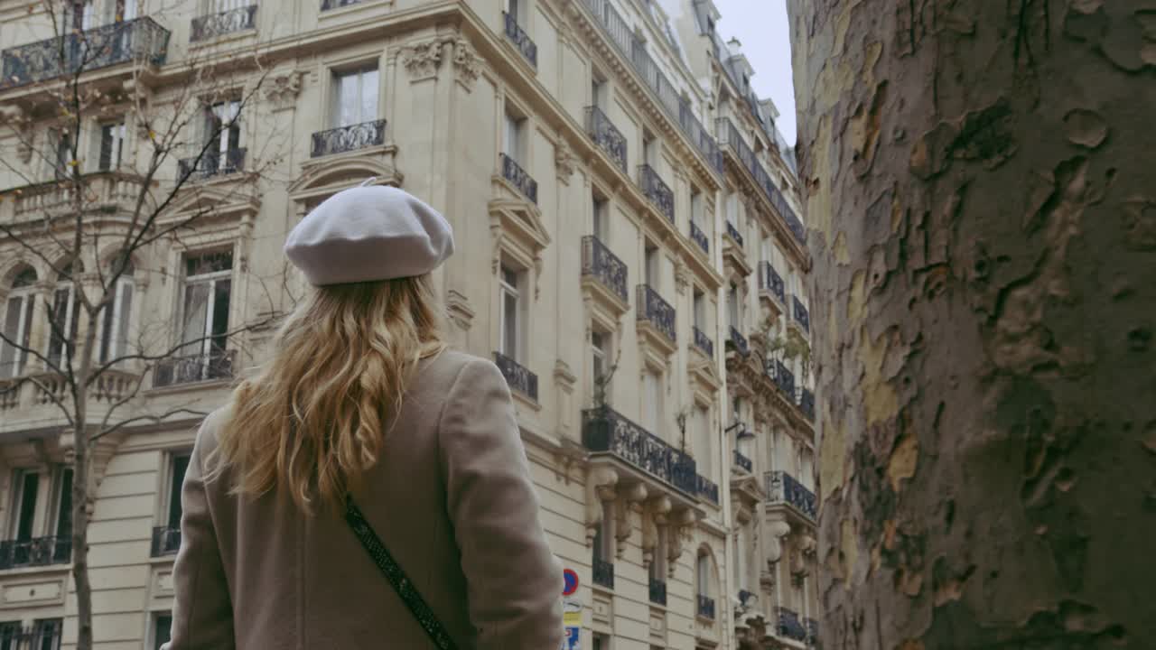 一个法国女人在附近的街道上看着埃菲尔铁塔视频下载