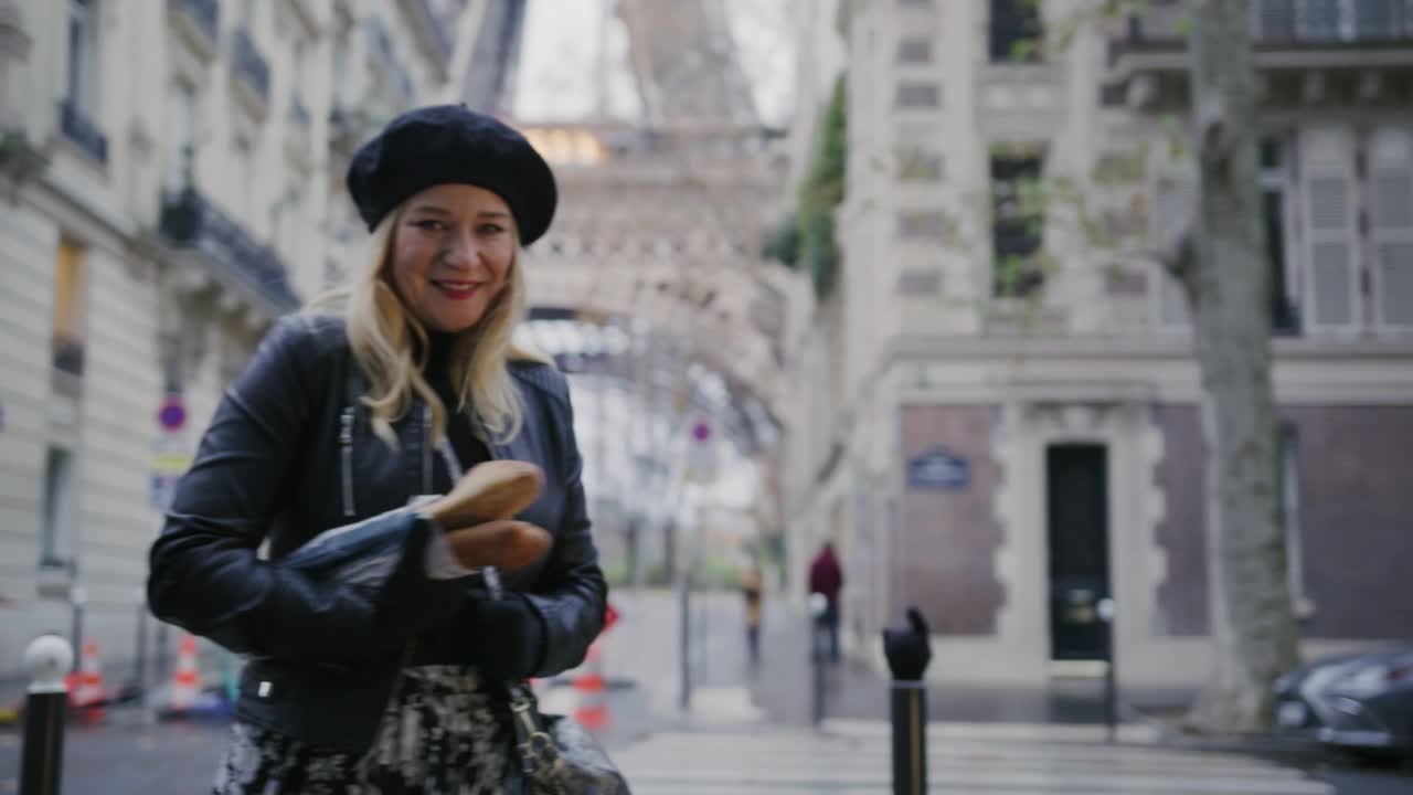 时尚的法国女人拿着法式长棍在埃菲尔铁塔摆造型视频下载