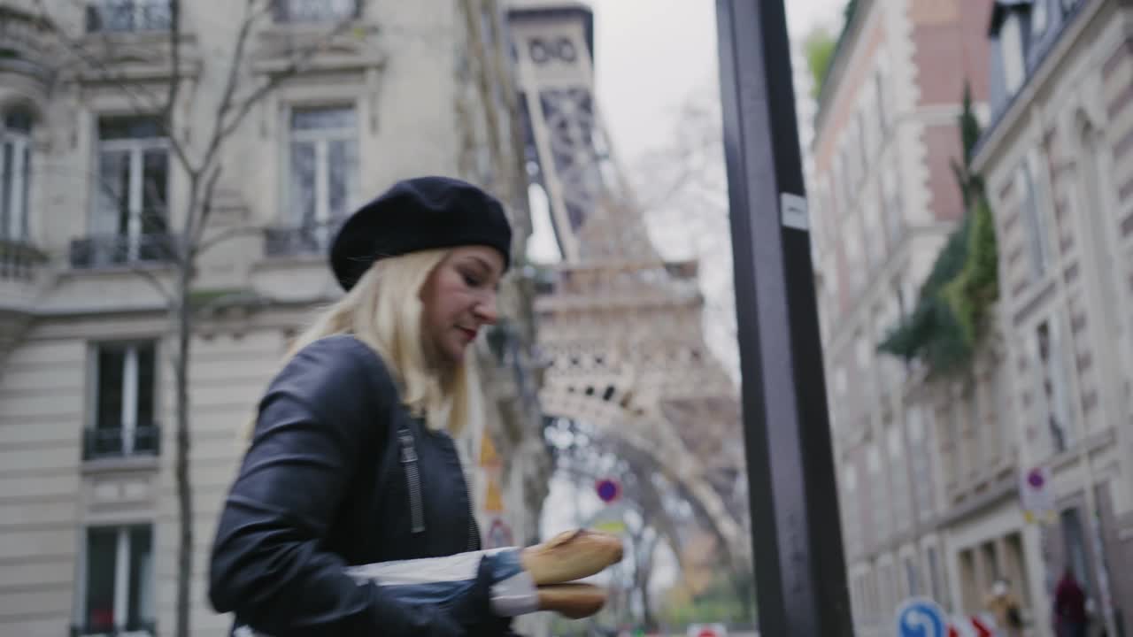 时尚的法国女人在埃菲尔铁塔边吃法式长棍面包视频素材