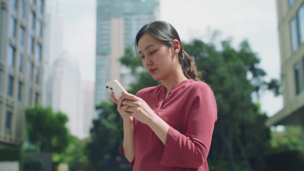兴奋的亚洲女人庆祝检查手机视频素材