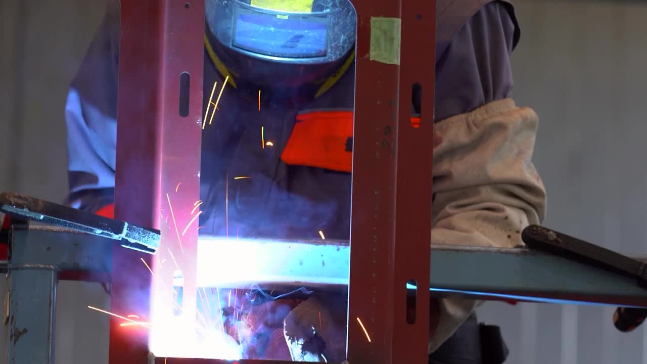 火车工厂的二氧化碳焊接-个人防护设备的焊工-放大镜头视频素材