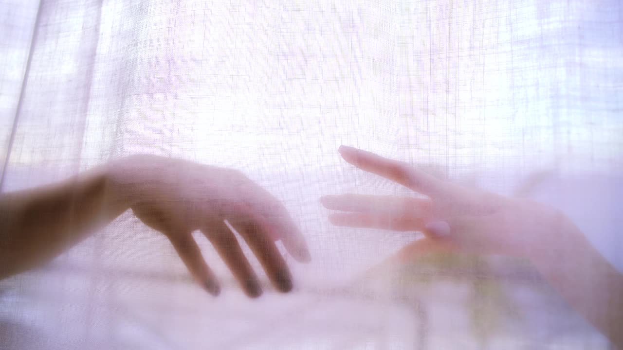 妩媚的女人躲在透明的窗帘后面。手之舞视频素材