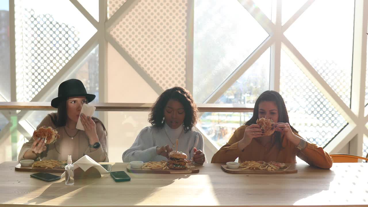 三个年轻而饥饿的女人来到购物中心的餐厅吃城里最好的汉堡视频下载