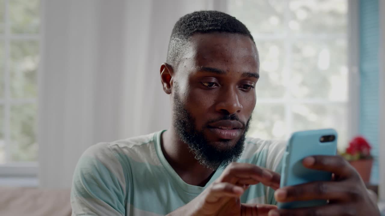 非裔美国年轻人在智能手机上聊天的特写。实时视频素材