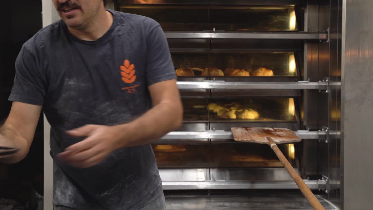 面包师将甜点放入热烤箱中视频下载