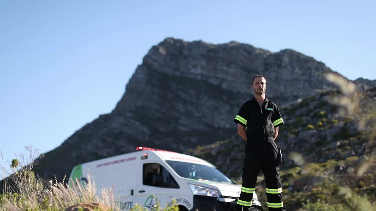 一名男性医护人员站在他的应急车辆前。视频下载
