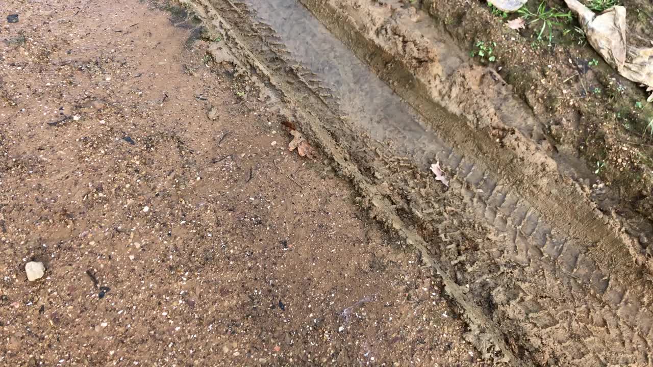 雨水灌进泥泞道路上的汽车轮胎印。视频素材