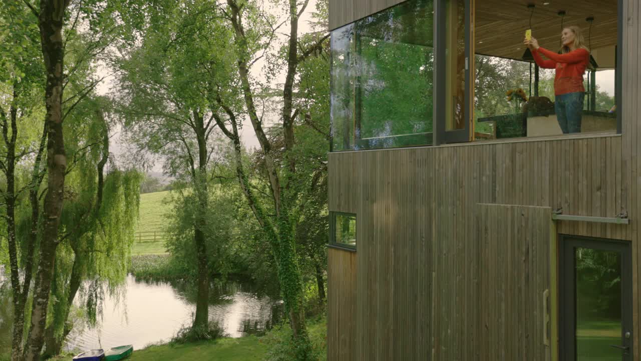 英国德文郡蒂弗顿现代住宅的妇女从窗户拍摄风景视频素材