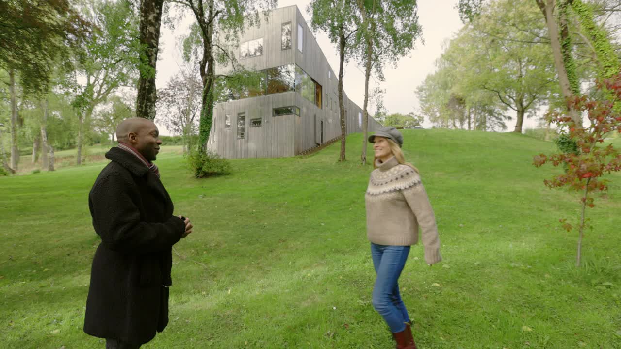 英国德文郡蒂弗顿，一对幸福的夫妇在现代木屋前拥抱视频素材