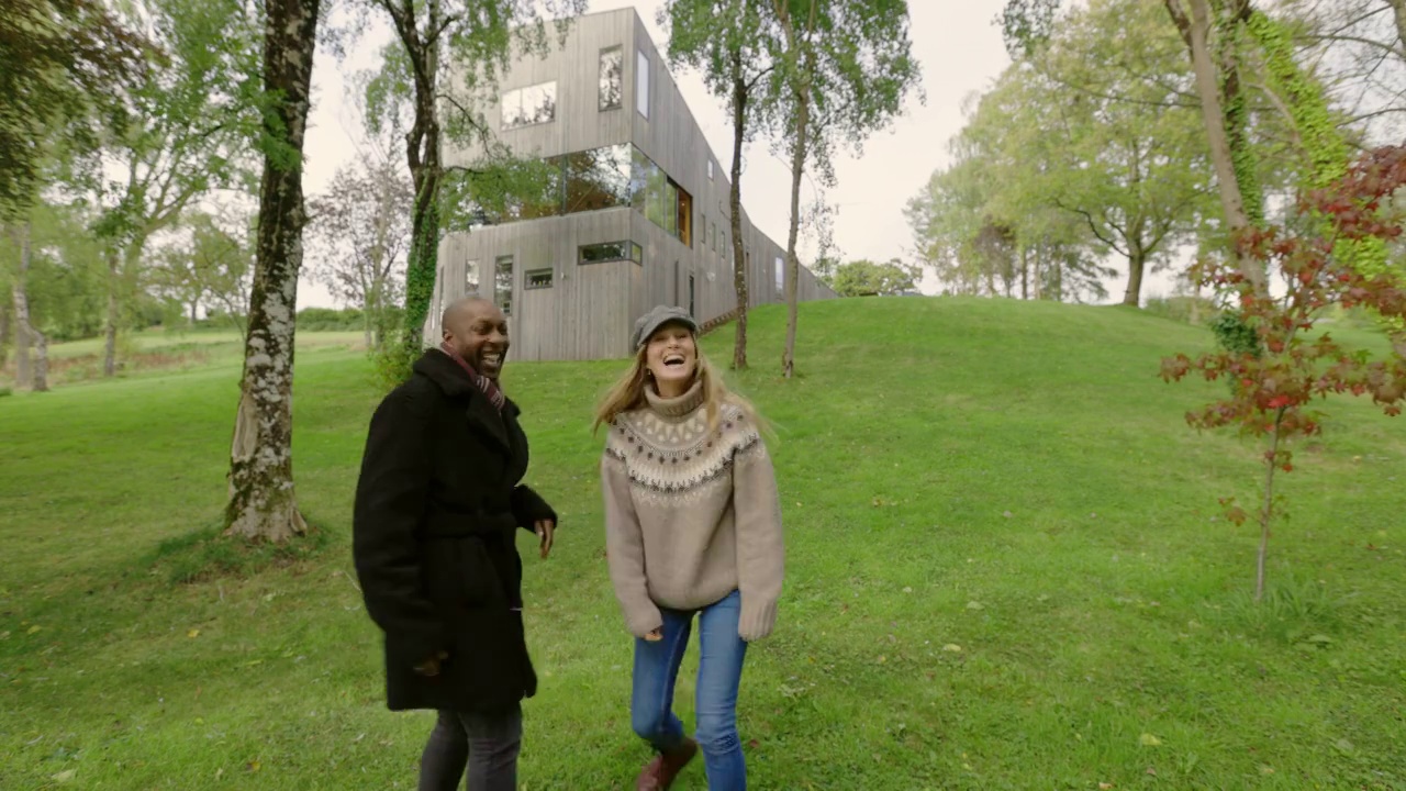 一对幸福的夫妇在英国德文郡蒂弗顿现代木屋前欢呼视频素材