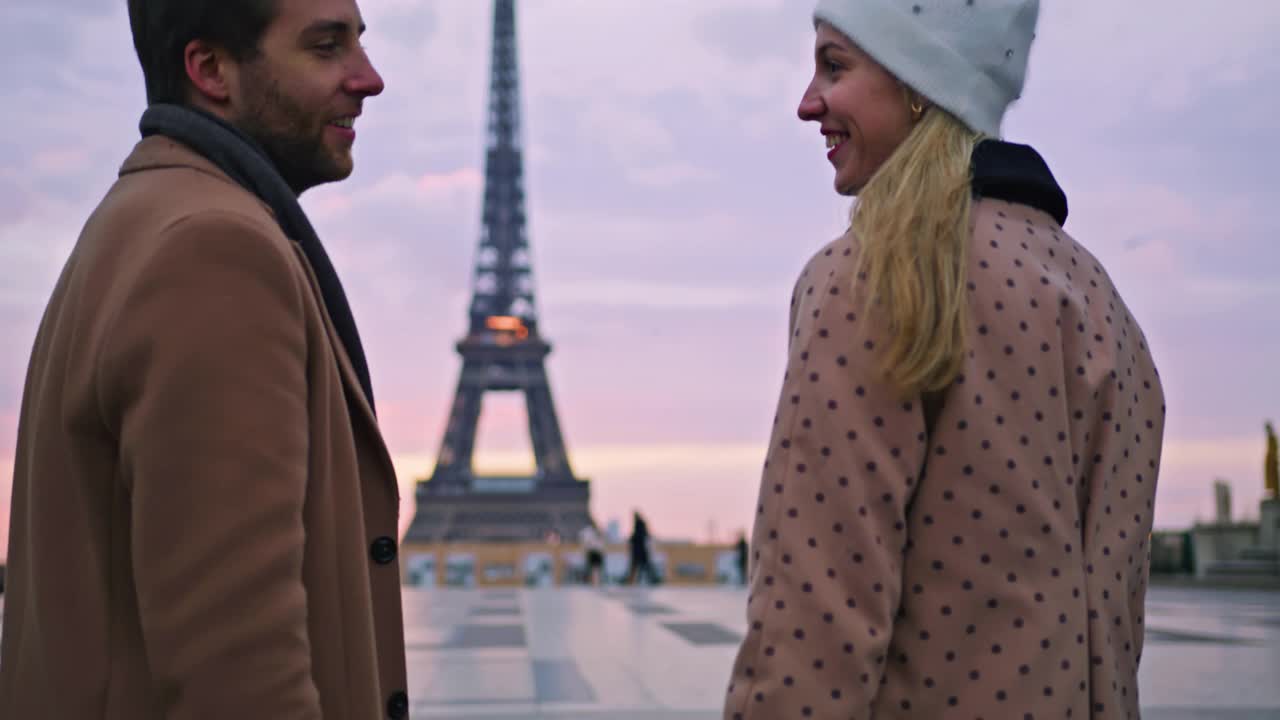 在巴黎埃菲尔铁塔旁，一对深情的情侣手牵着手，享受着深情的时刻视频下载