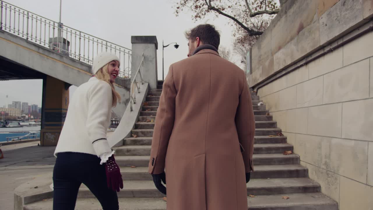 这对恩爱的情侣走在艾菲尔铁塔旁塞纳河上的楼梯上视频素材