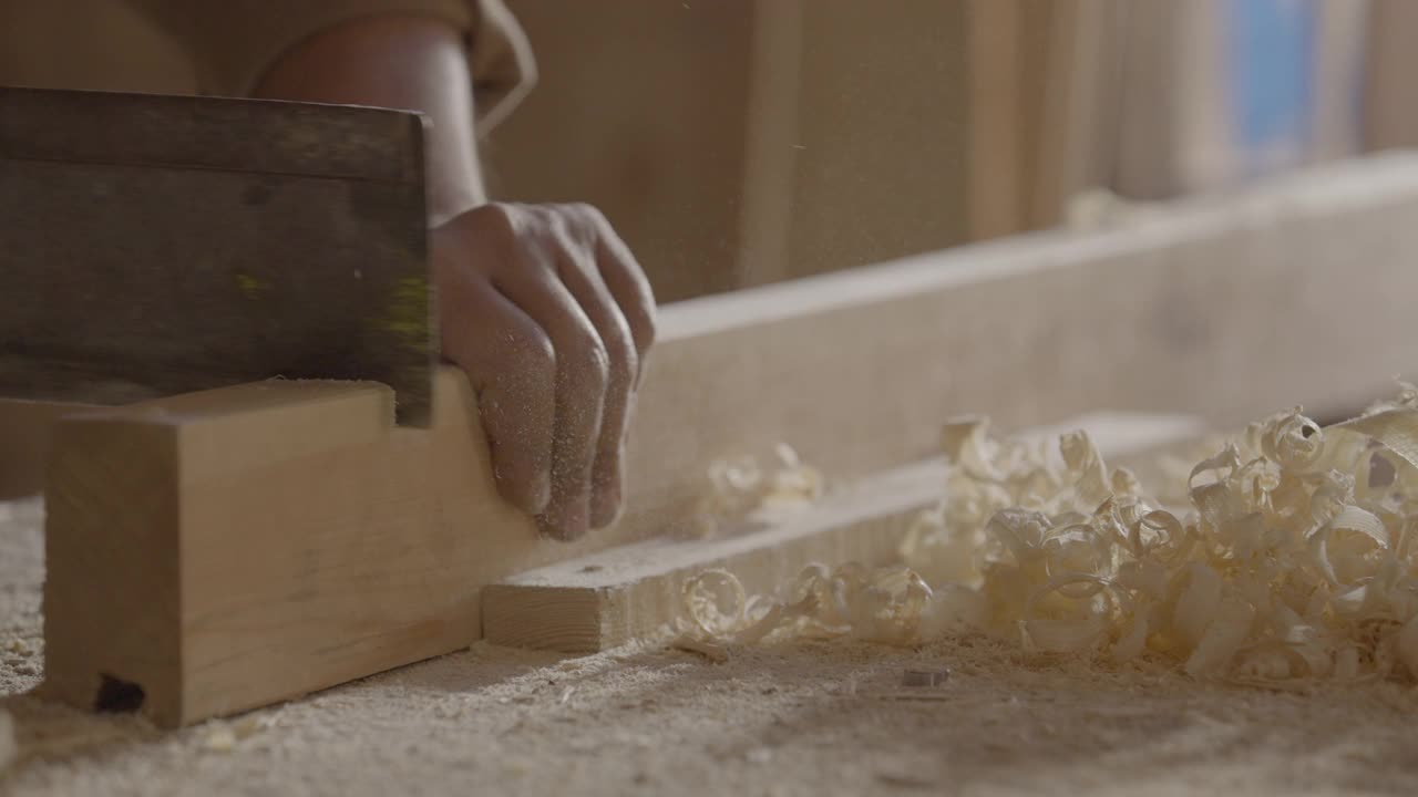 一个木匠用榫锯锯木板的静态镜头视频下载