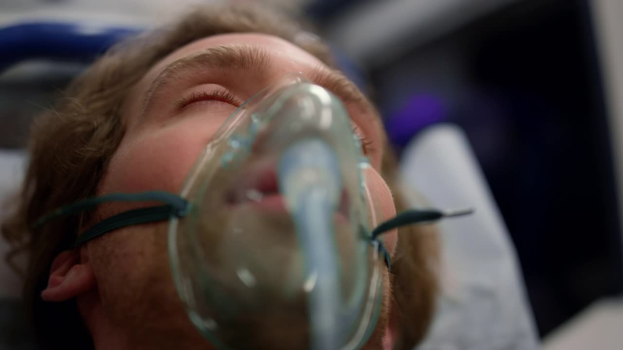 一名冠状病毒感染者躺在救护车的担架上。护理人员进行急救视频素材