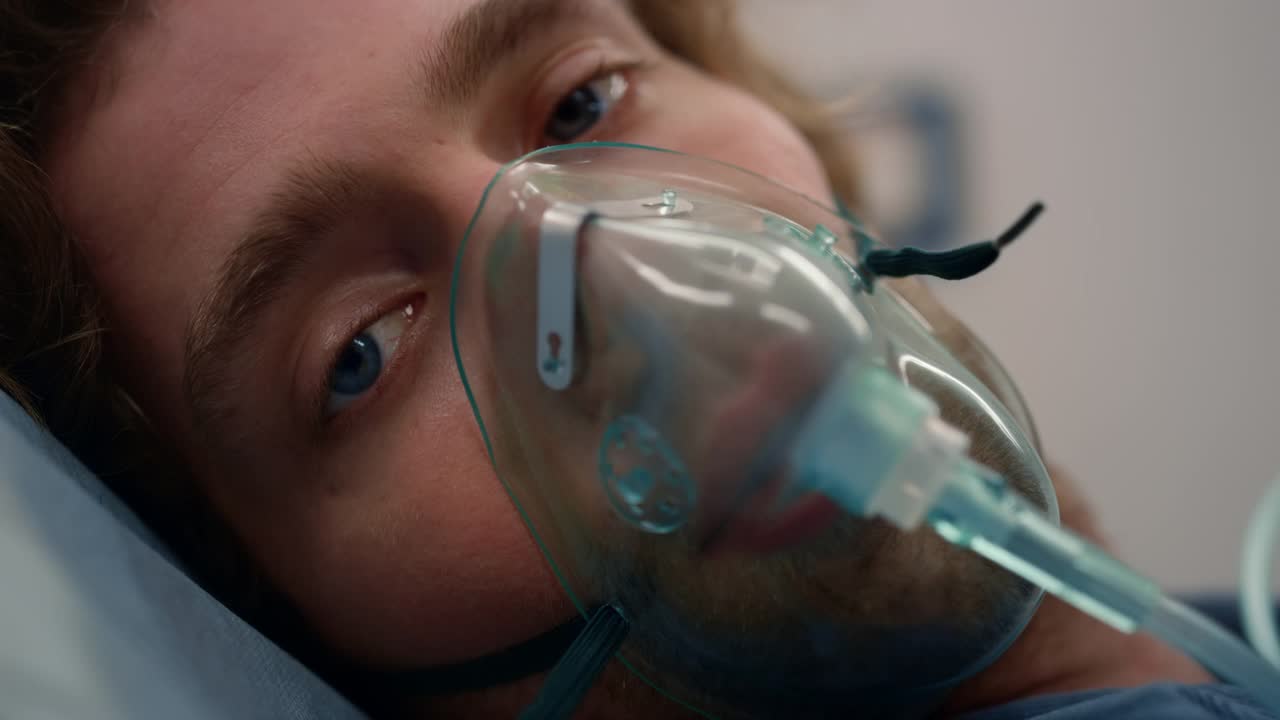 特写病人戴着氧气面罩躺在急救车的担架上视频素材