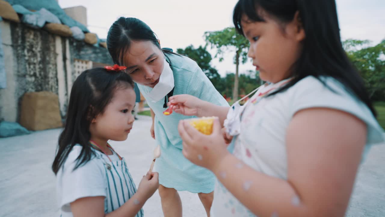 亚洲姐妹和姐妹快乐吃冰淇淋。视频下载