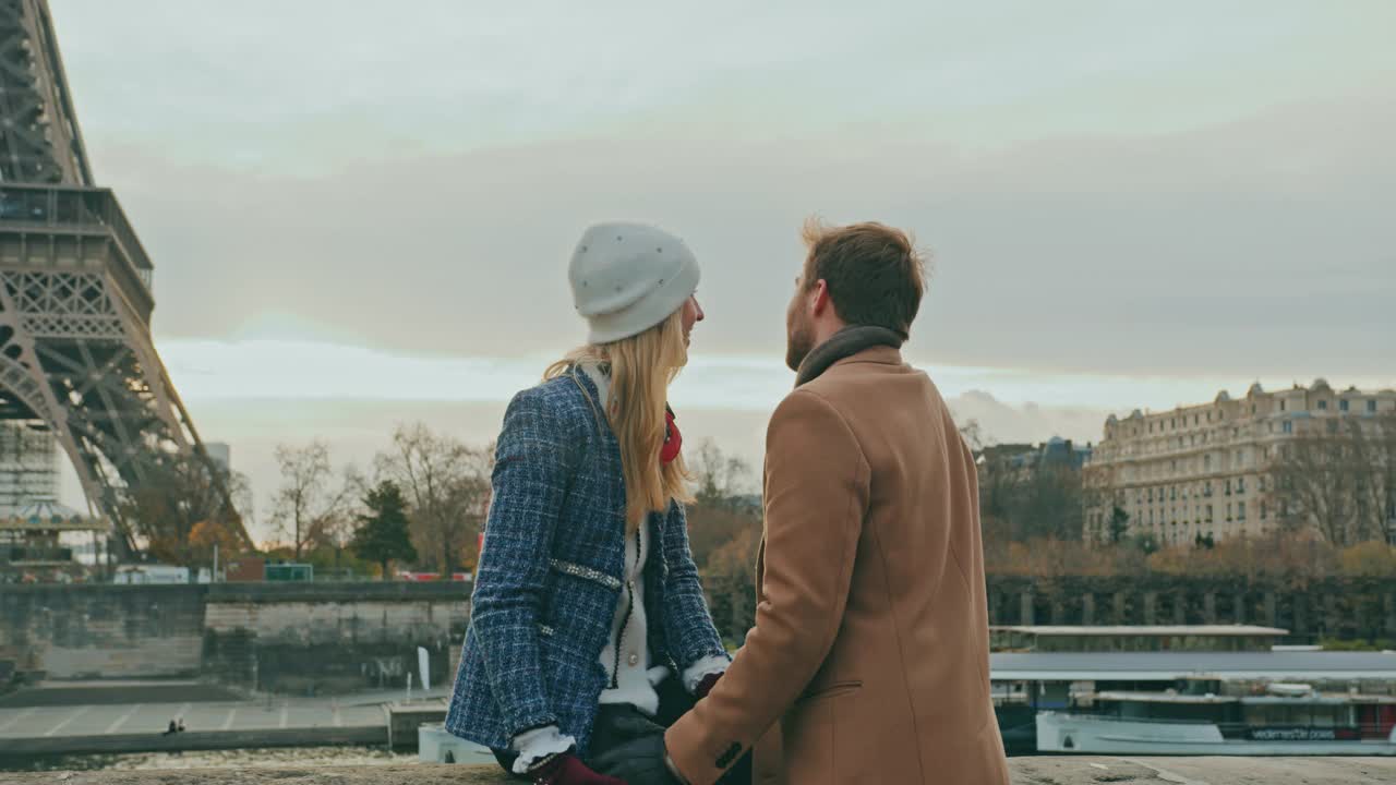 一对年轻夫妇在艾菲尔铁塔旁的人行道上深情相吻视频素材