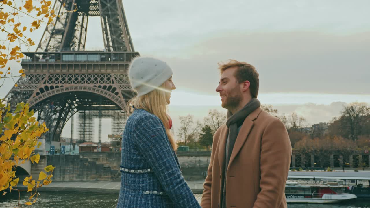 一名年轻女子在埃菲尔铁塔旁亲吻男友的脸颊视频素材